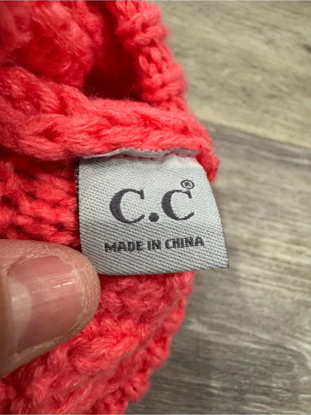 C.C. brand baby beanie w/ coral-colored cable knit design w/ two plush pom poms